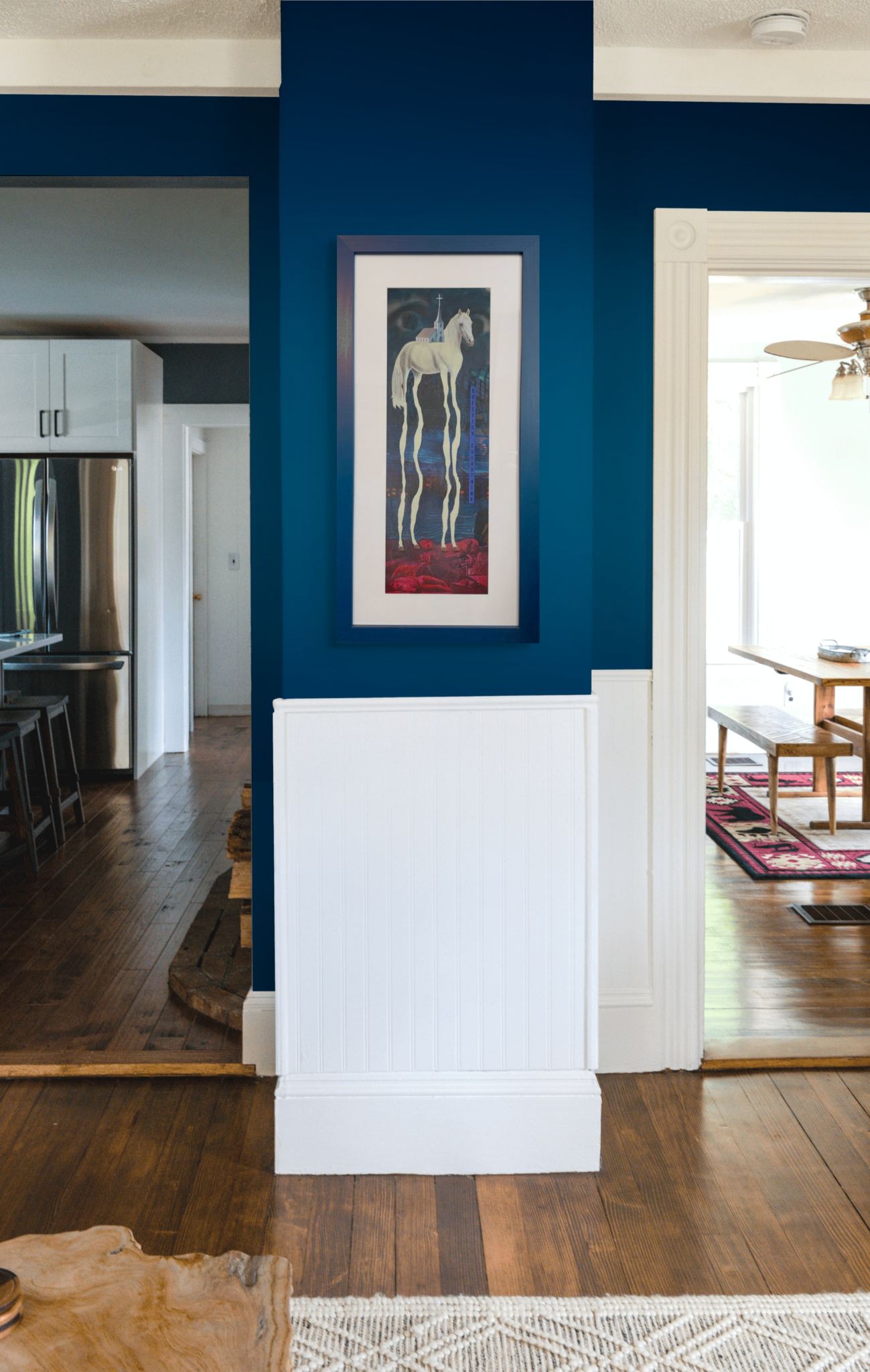 Framed artwork of a horse on a blue wall in a home interior.