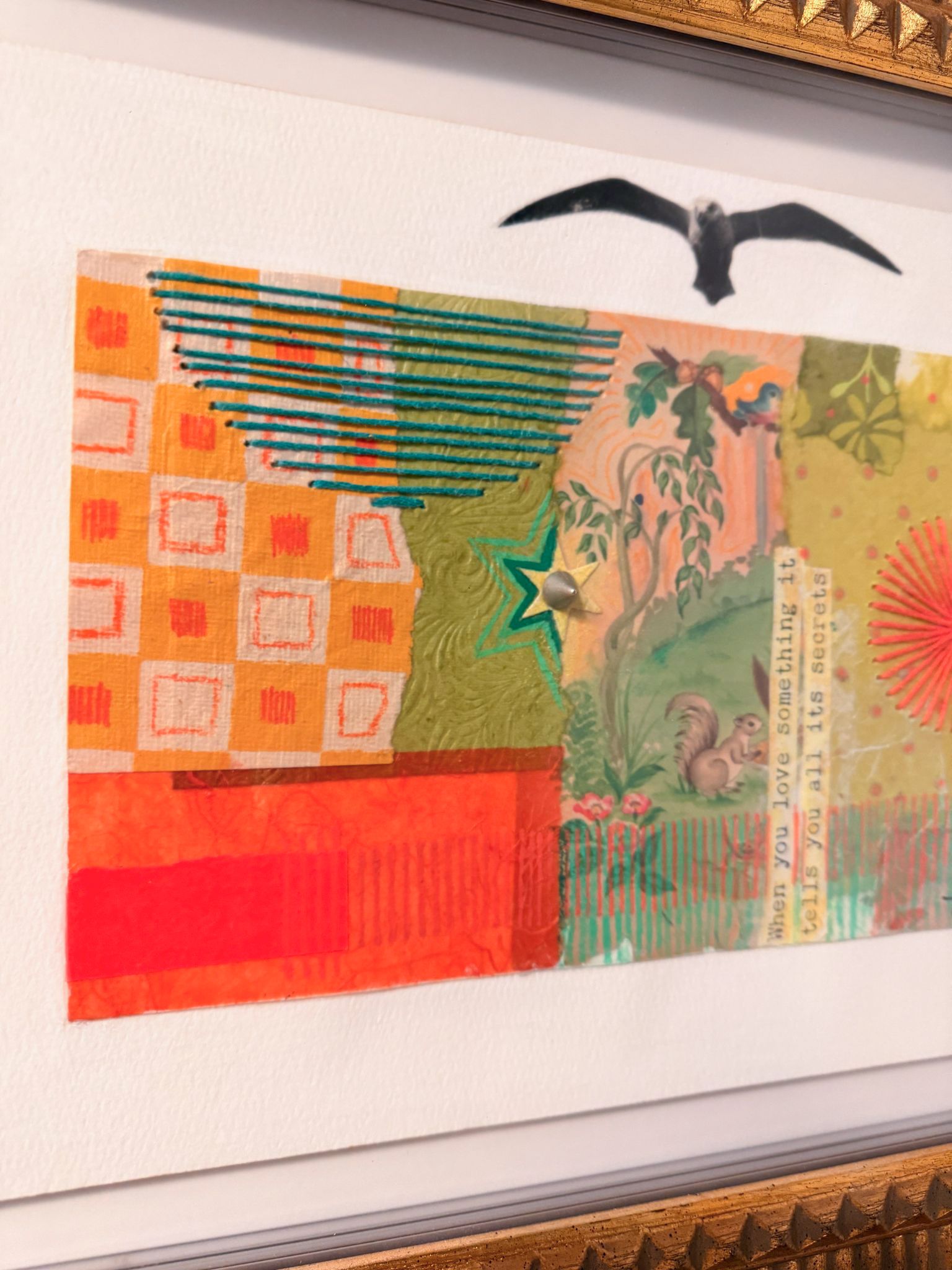 Close-up shot of colorful abstract artwork with birds in a gold frame